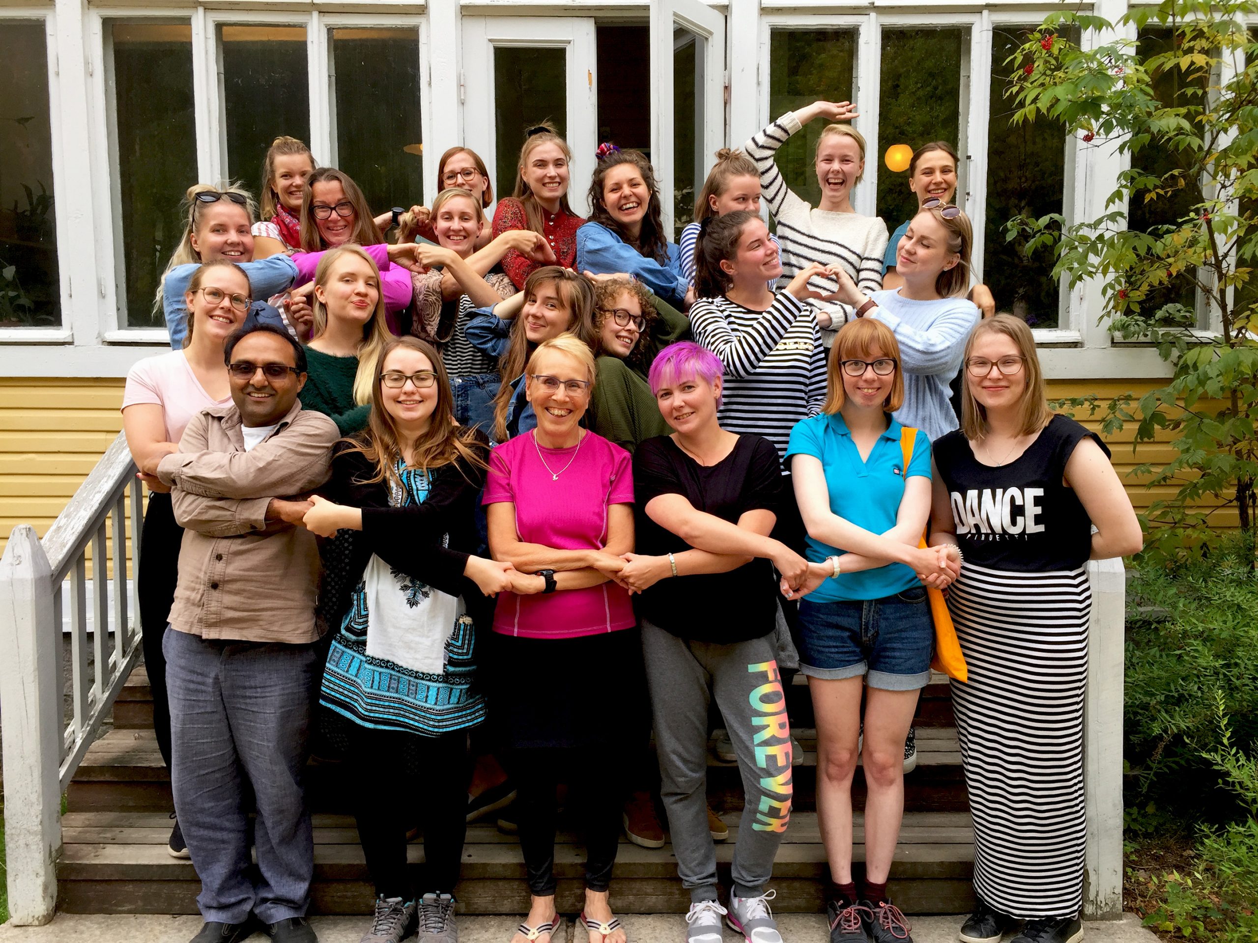 Iloisessa ulkona kesällä otetussa ryhmäkuvassa 22 globaalikasvatuksen kouluttajaa.