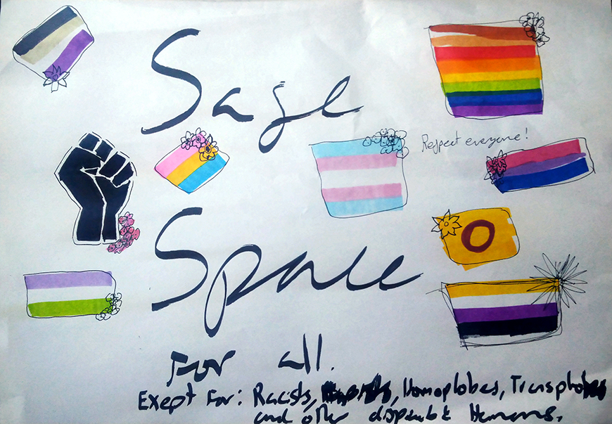 Teksti Safe Space eli turvallinen tila, ympärillä erilaisia erivärisiä pieniä lippuja mm. seksuaalivähemmistöjen lippuja.