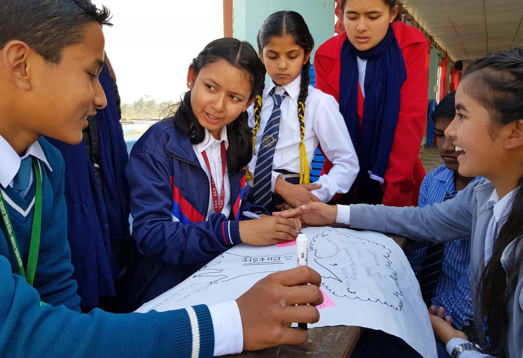 Oppilaskunnan jäseniä pöydän ääressä Nepalissa.