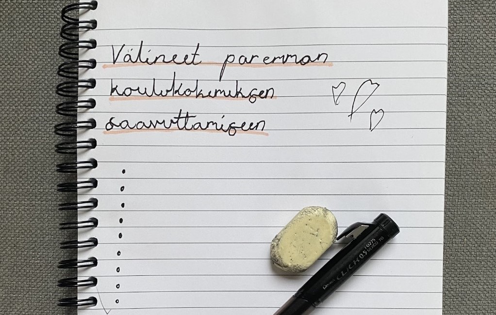 Vihko, kynä ja kumi, vihkoon on kirjoitettu tekti Välineet paremman koulukokemuksen saavuttamiseen.