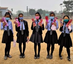 5 tyttöä koulupuvuissa pitelee käsissään kestositeitä.