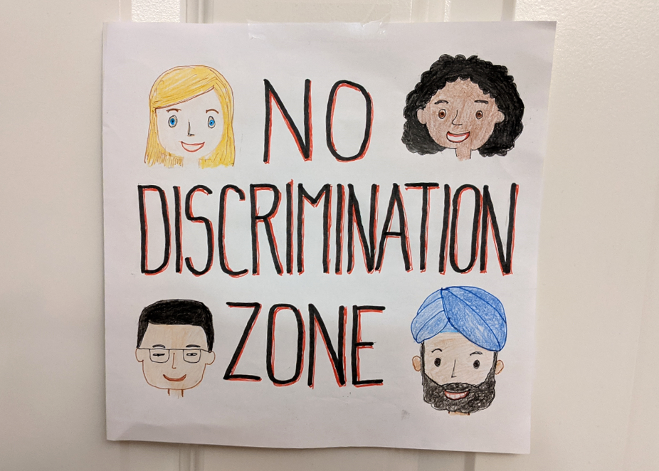 Paperille on piirretty 4 erilaisen ihmisen kasvot, keskellä on teksti No discrimination zone eli Syrjinnästä vapaa alue.