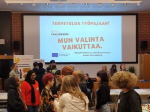 Kuvassa nuoria työpajan osallistujia sekä taustalla dia-esitys, jossa teksti Tervetuloa työpajaan! Mun valinta vaikuttaa sekä Taksvärkki Challengers-logo.