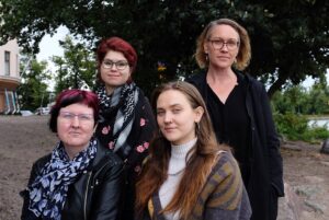 Neljä aikuista ryhmäkuvassa.