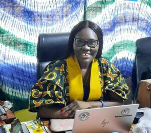 Hymyilevä nainen kannettavan tietokoneen ääressä.